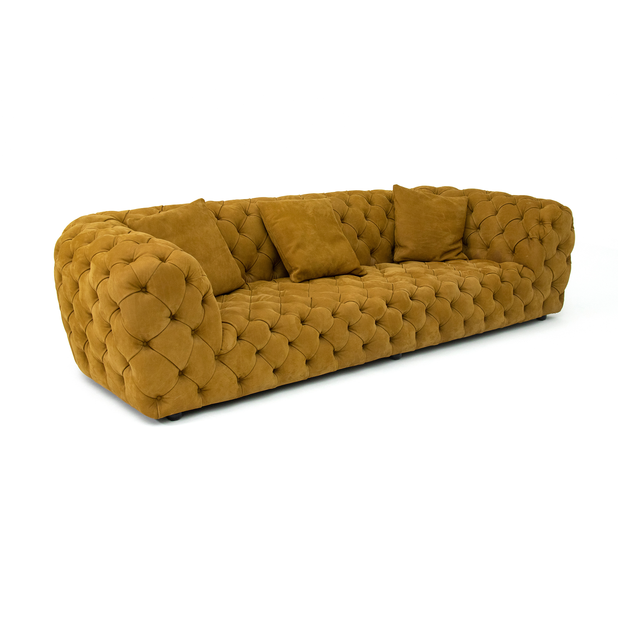 Photograph of the Chester Moon Sofa designed by Paola Navone for Baxter. The sofa features deep hand-tufted upholstery crafted from natural leather, creating a distinctive crater-like texture reminiscent of the moon’s surface. Its soft curves and voluminous form merge traditional craftsmanship with a contemporary sculptural aesthetic. Built for both comfort and artistry, the Chester Moon Sofa embodies Italian luxury and poetic design.