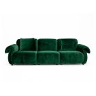 Green velvet sofa with soft cushions and two matching bolsters showing modern cozy design.