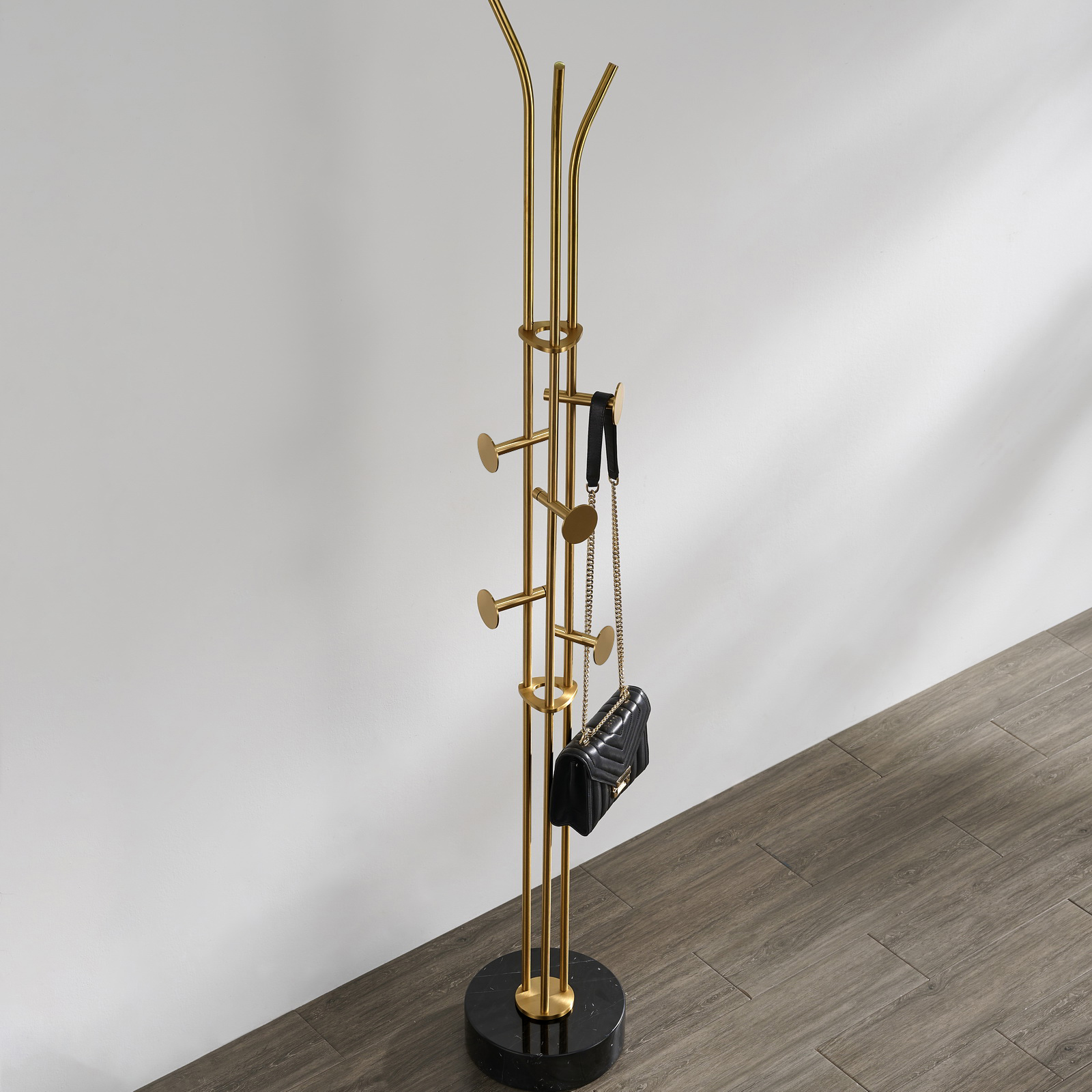 Stainless steel coat rack stand with black marble base and brushed gold-tone adjustable hooks